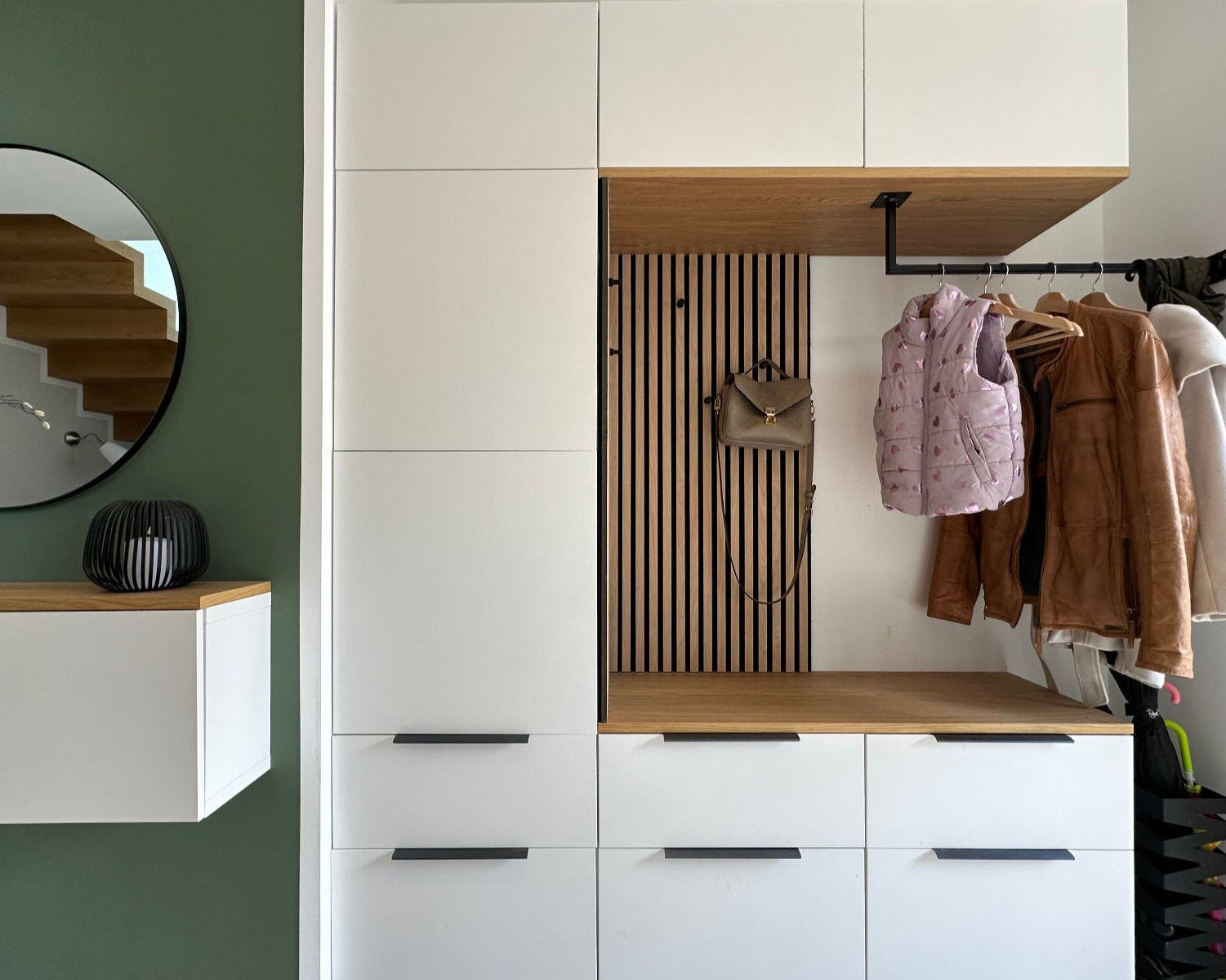 DIY Ikea Garderobe im Eingangsbereich, hier hängen Jacken und eine Handtasche, gebaut aus IKEA Besta