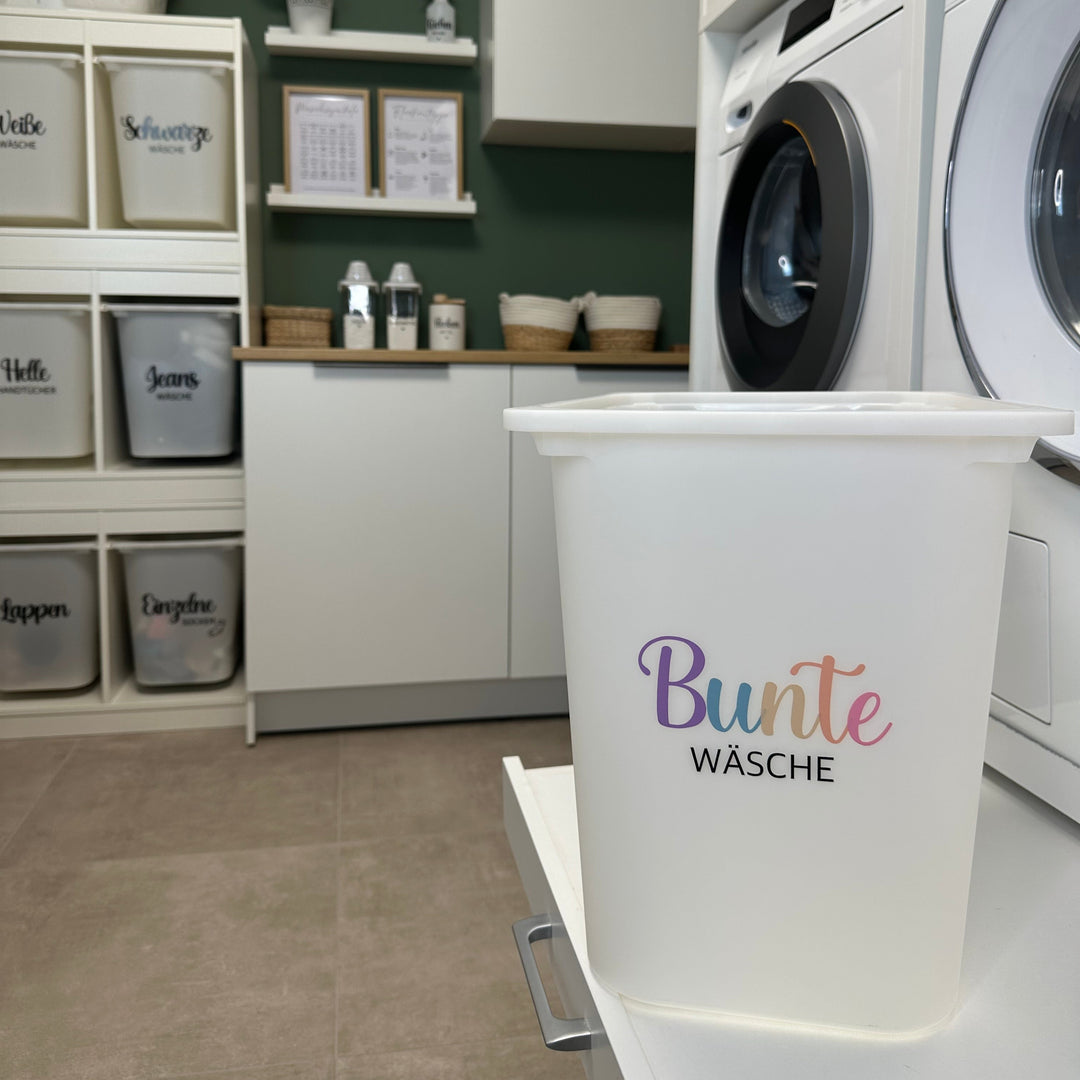 Wäschebox mit Aufkleber Bunte Wäsche in Pastellfarben vor Waschmaschine