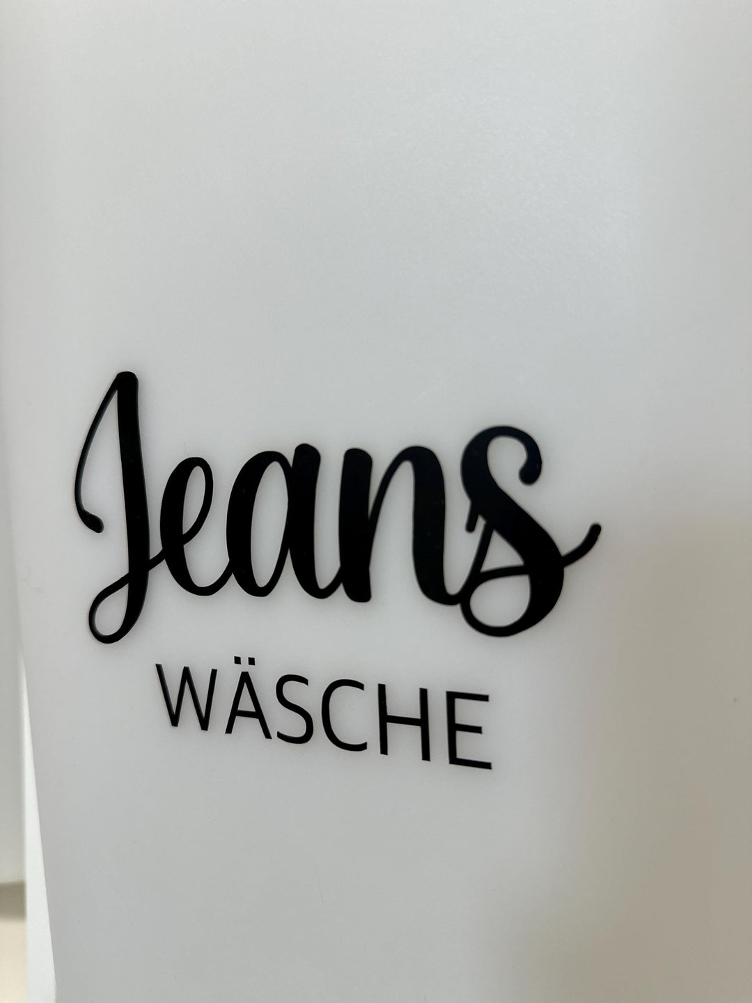 Nahaufnahme: Jeans Wäsche Sticker in schwarzer Schrift